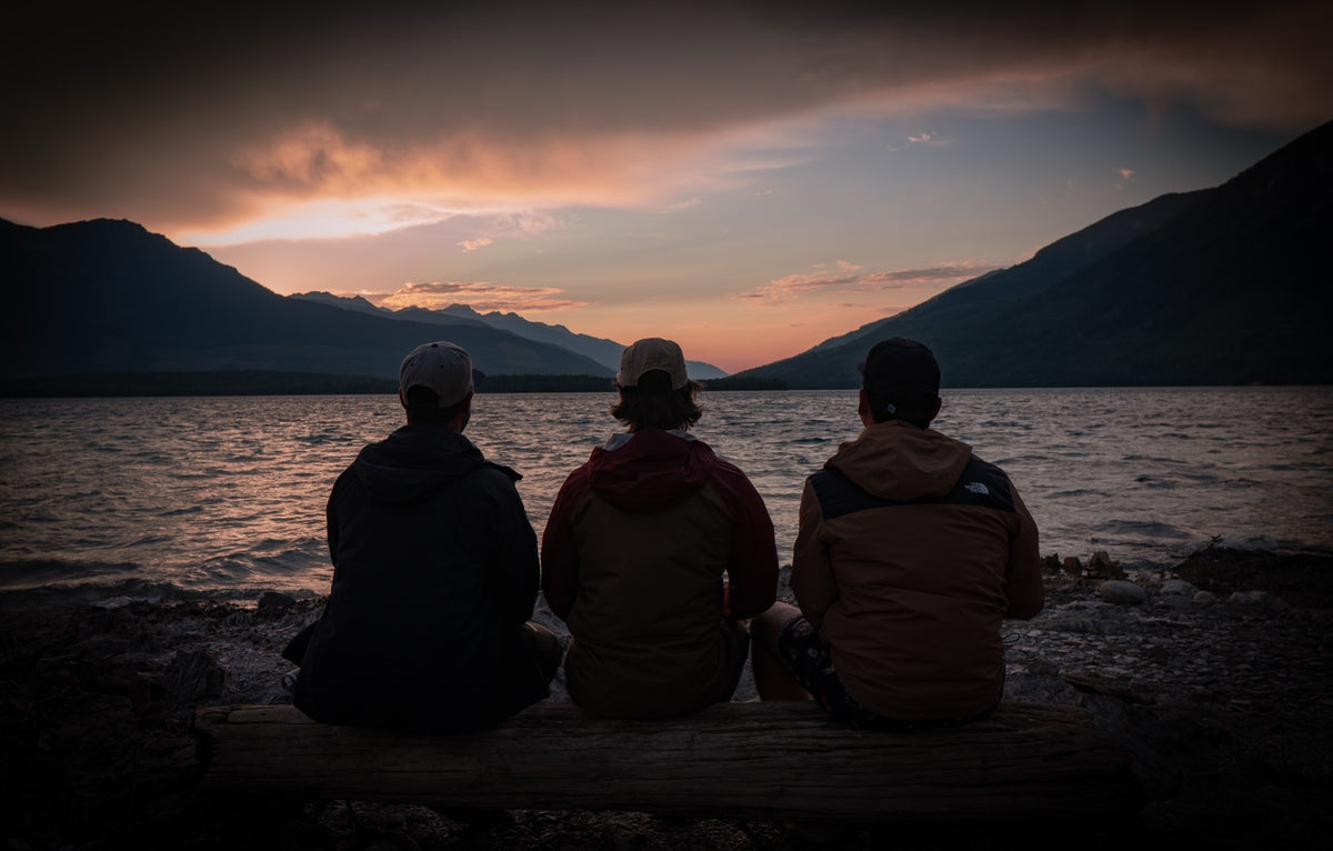 Three friends watching sunset over Kinbasket Lake