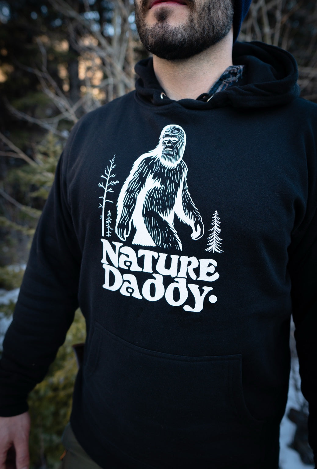 Black Nature Daddy Sasquatch hoodie worn outdoors